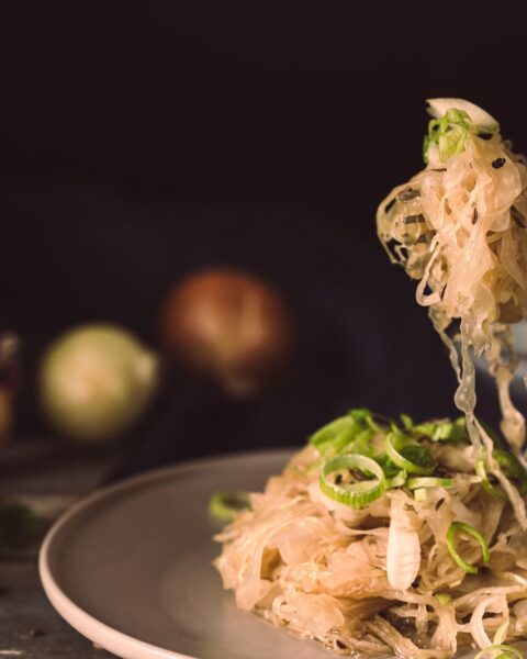 Bord met zuurkool, bestrooid met lente-ui, klaar om te eten
